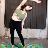 Sexy redhead solo girl Cleo unleashes her huge breasts during a yoga routine