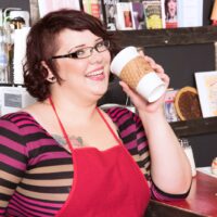 Redhead BBW Kitty McPherson sports short hair and glasses while getting nude in a cafe