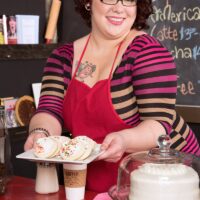 Ginger-haired fatty Kitten McPherson sports short hair and glasses while getting naked in a cafe setting