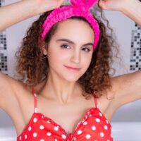 Petite teen with curly hair Kiera takes off a summer dress before taking a bubble bath