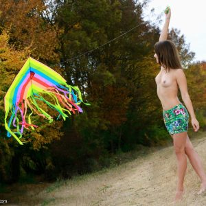 Beautiful brunette teen Emmy gets totally naked while flying a kite in the outdoors