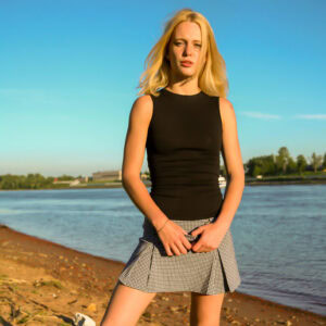 Barely legal blonde Petrina steps into the water while exposing her tight slit